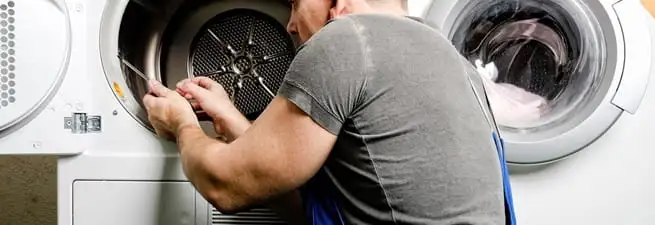 Dryer repair technician fixing a clothes dryer drum in San Diego, CA