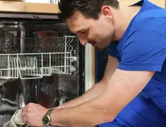 Dishwasher repair technician inspecting and servicing an open dishwasher in San Diego, CA