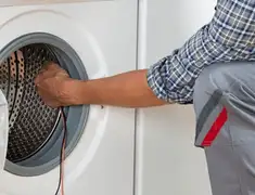 Dryer repair technician diagnosing and servicing a clothes dryer in San Diego, CA