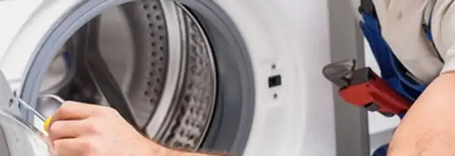 Appliance technician repairing a clothes dryer drum and internal parts in San Diego, CA