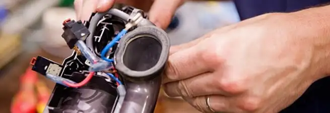 Vacuum repair technician reconnecting wiring and components in San Diego, CA